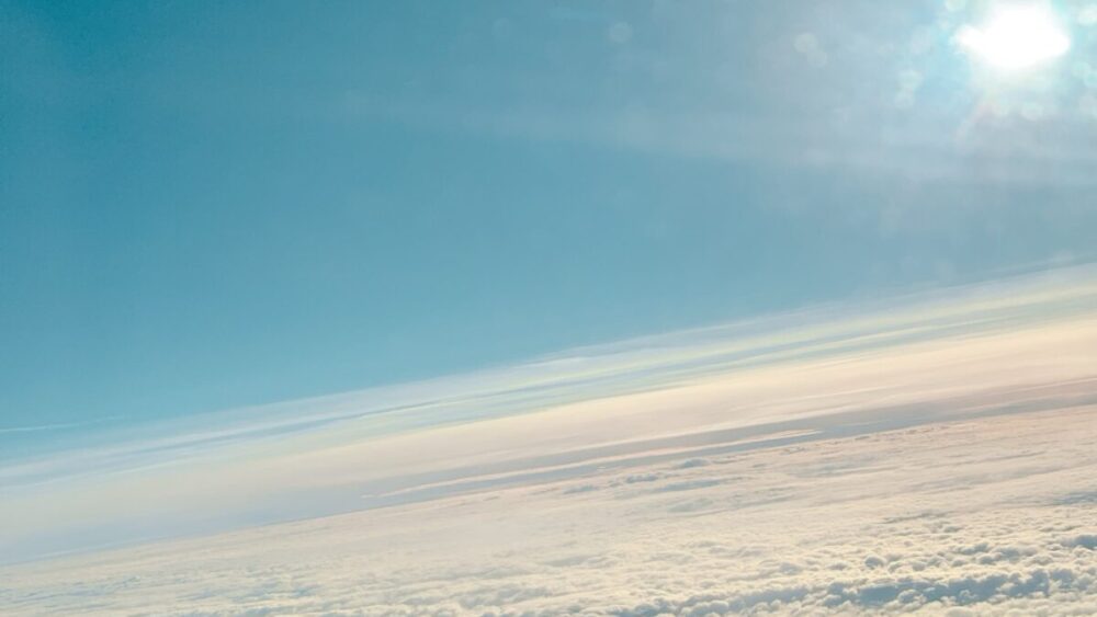 飛行機の窓から見た雲海とやわらかな光の空